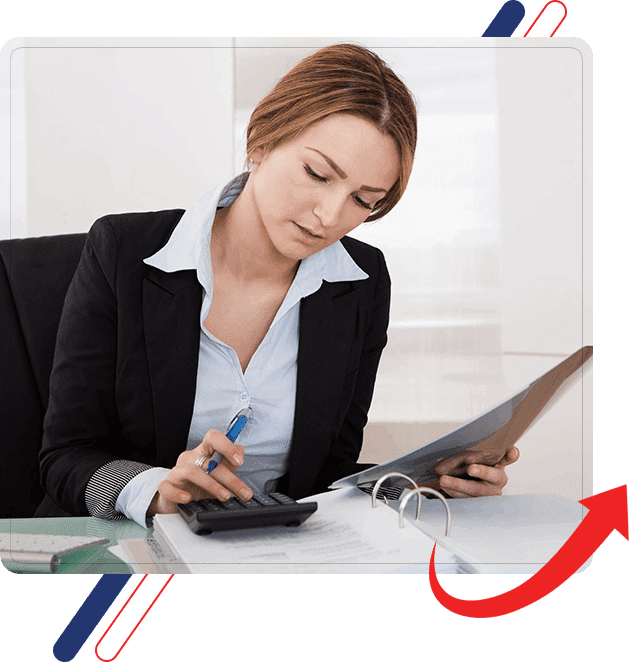 A woman sitting at her desk with papers and a calculator.