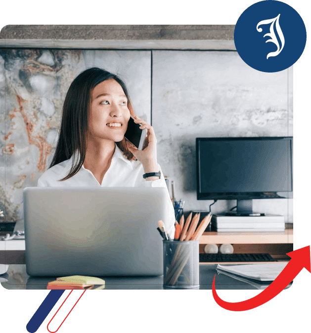 A woman sitting at her desk on the phone