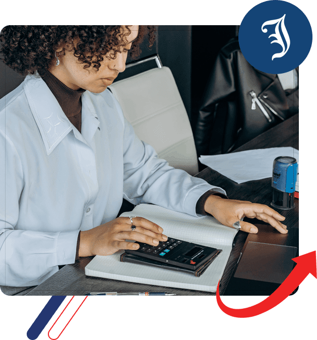 A woman using a calculator on top of a laptop.