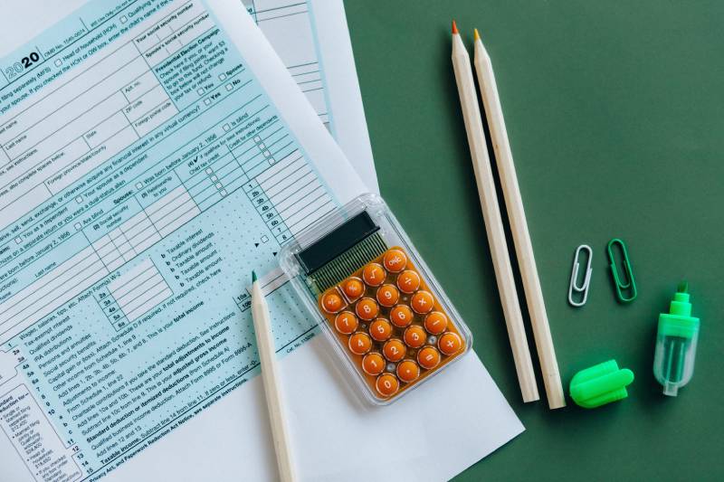 A calculator and some pencils on top of a table.